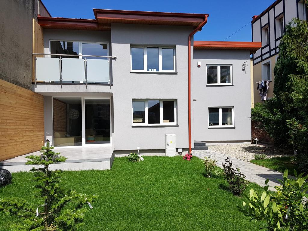 a white house with a lawn in front of it at Villa Koffi Apartments 16 plus in Puck
