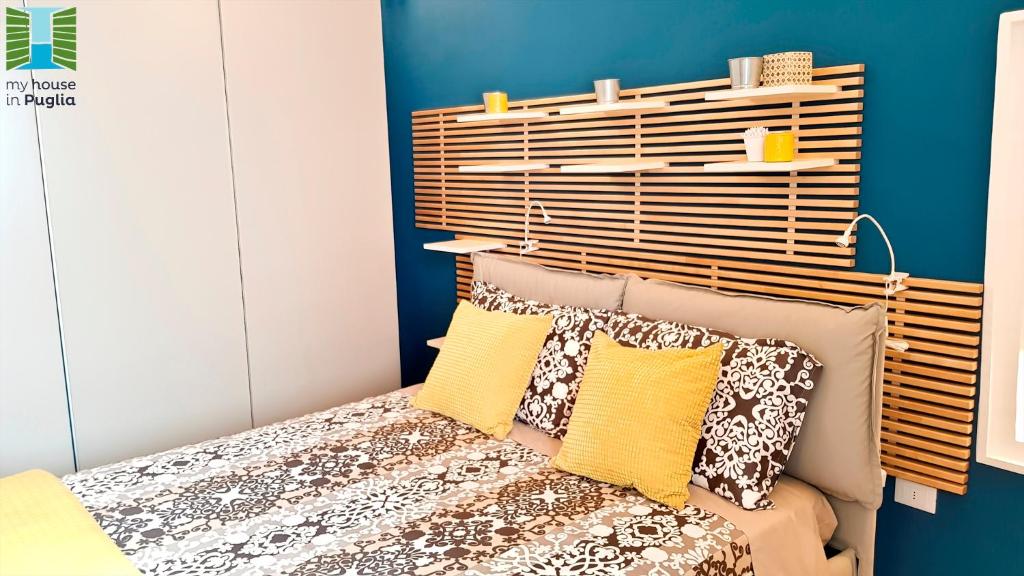 een slaapkamer met een bed met een houten hoofdeinde bij Borgo Guesthouse in Monopoli