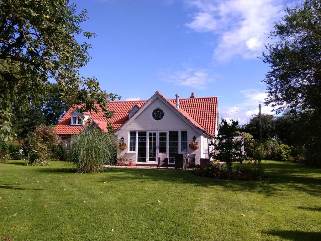 Casa blanca con techo rojo y patio en White Cottage B and B en Spilsby