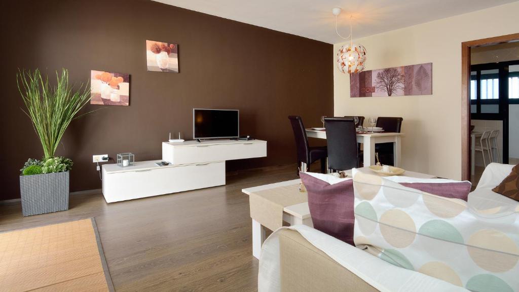 a living room with a couch and a tv at Villa Isla Feliz in Playa Blanca