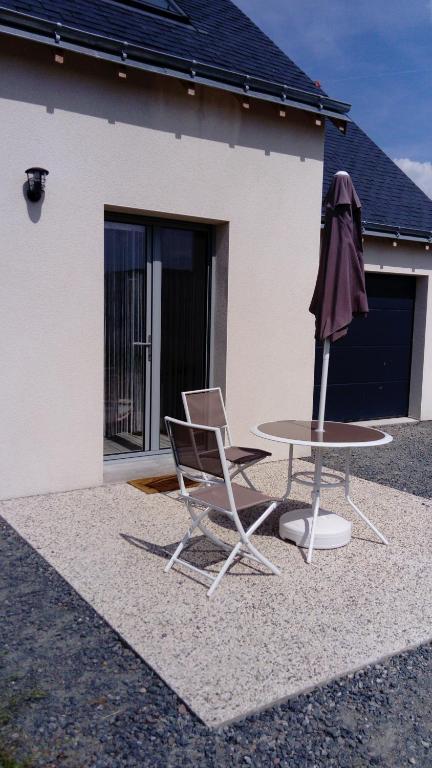 een tafel en een stoel en een paraplu voor een huis bij Chez Elisa in Chinon