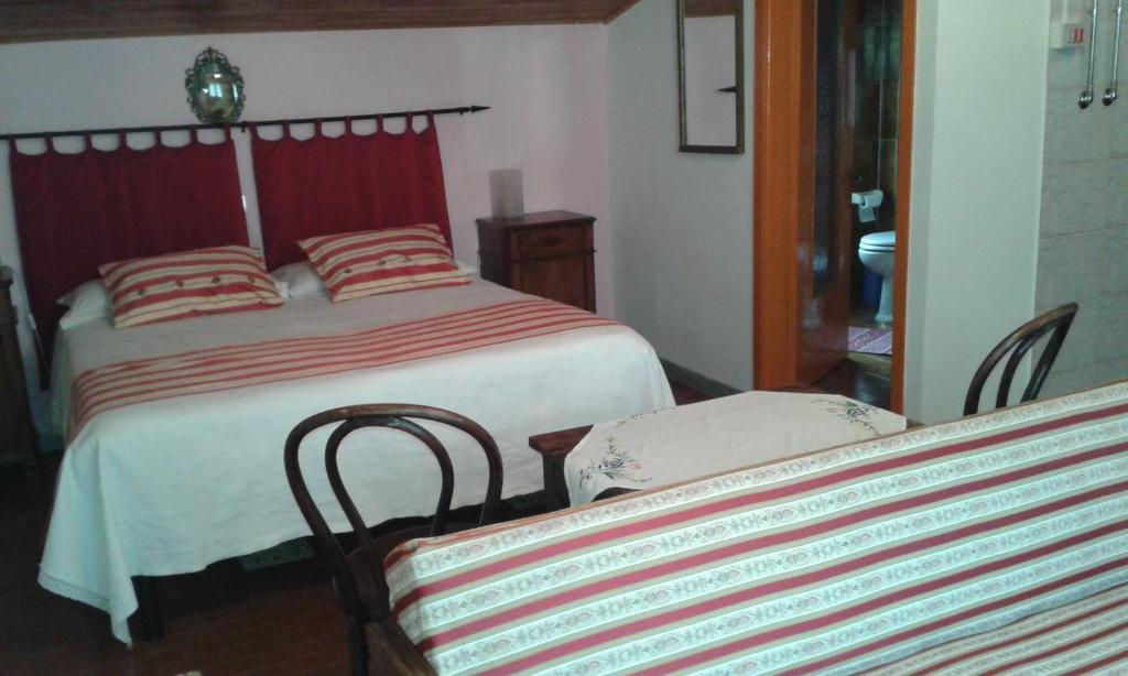 a bedroom with two beds and two chairs at Agriturismo Ribuntà in Caiolo