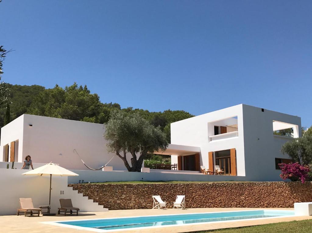 a villa with a swimming pool and a house at Can Poeta in Sant Carles de Peralta