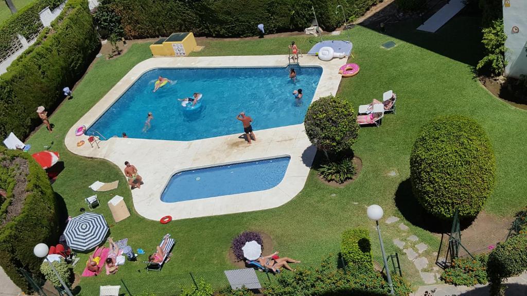 een groep mensen die zwemmen in een zwembad bij Gamonal 25 in Benalmádena