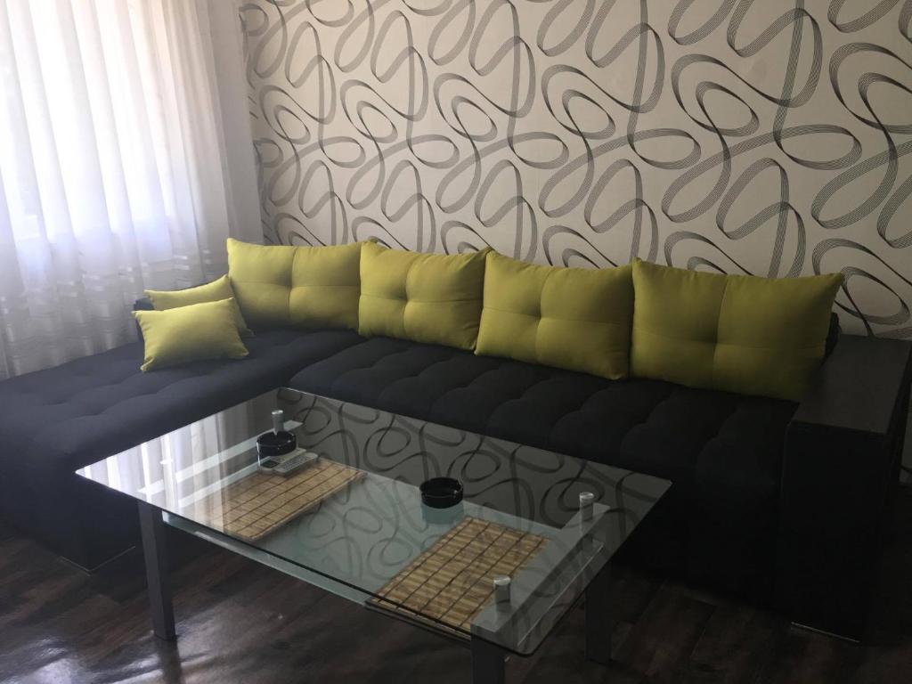 ヒサリャにあるApartment Bulgariaの黒いソファ(黄色い枕、テーブル付)