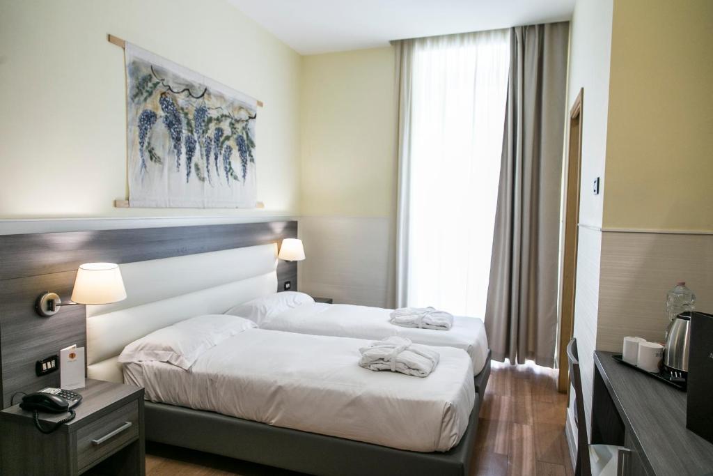 una camera d'albergo con due letti e una finestra di Hotel Aphrodite a Roma