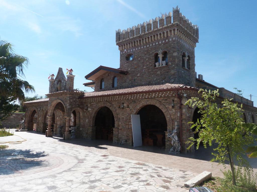 un grande edificio in mattoni con una torre dell'orologio di Country House 3Quatrì a Corropoli