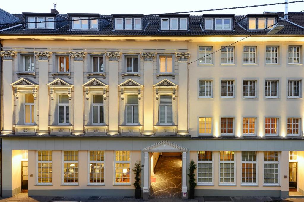 Carlstadt Suites Düsseldorf في دوسلدورف: مبنى أبيض كبير مع العديد من النوافذ