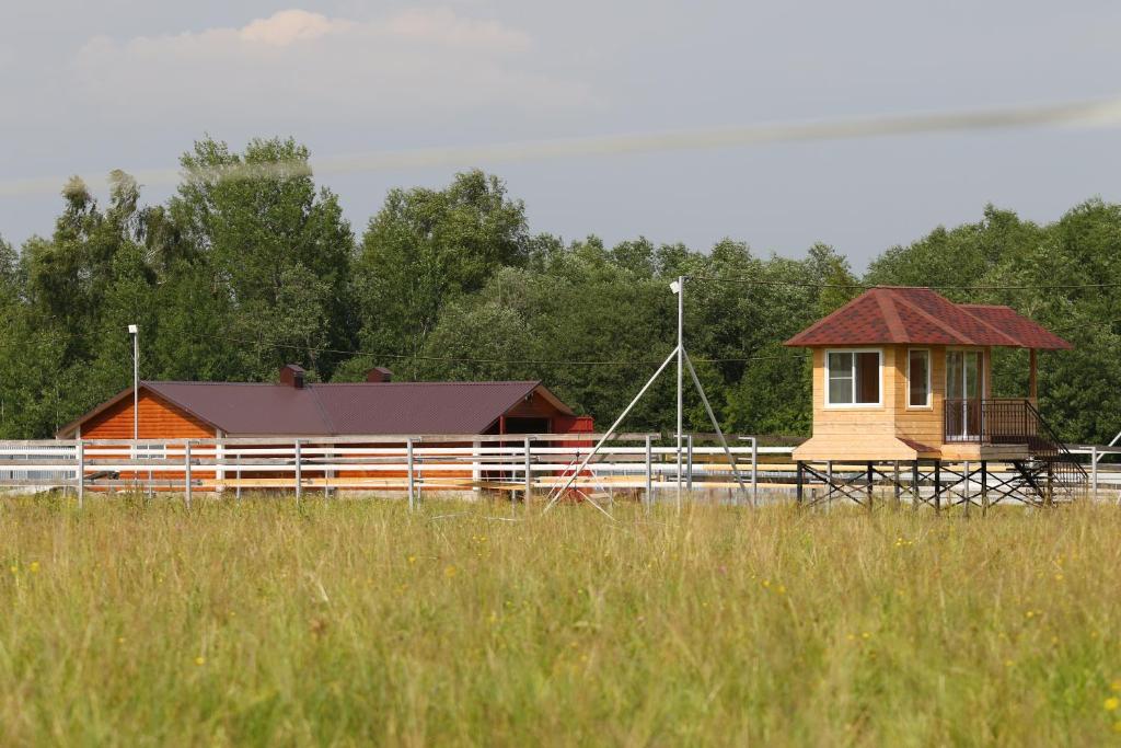 a small house in a field next to a fence at Villa Krasivaya in Tarusovo