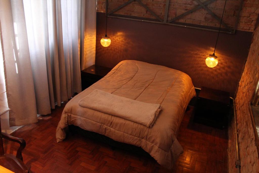 1 dormitorio con 1 cama en una habitación con luces en NeighborHUB hostel e coliving en São Paulo