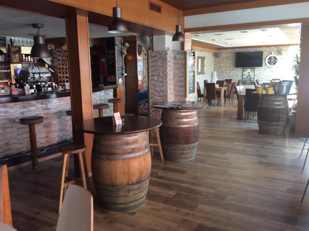 a bar with wooden stools and wooden barrels at Pension Pukel in Schiefling am See