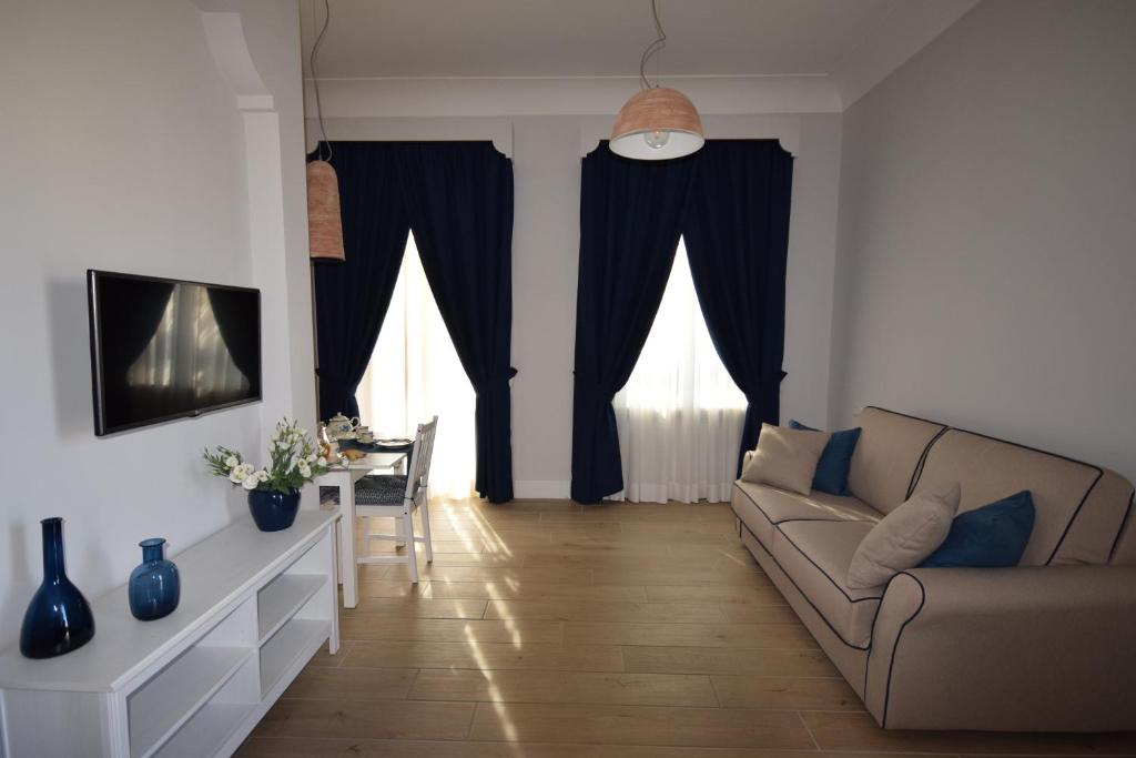 a living room with a couch and a table at Fondo Santa Lucia in SantʼAgata sui Due Golfi