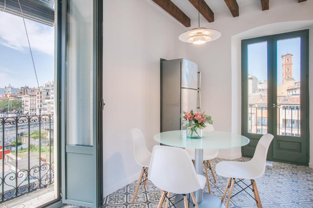 ジローナにあるFlateli Rambla 5 3-2のテーブルと椅子、バルコニーが備わる客室です。