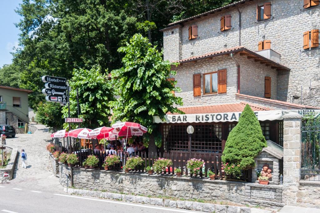 a restaurant with umbrellas in front of a building at Hotel Da Giovanna in Chiusi della Verna