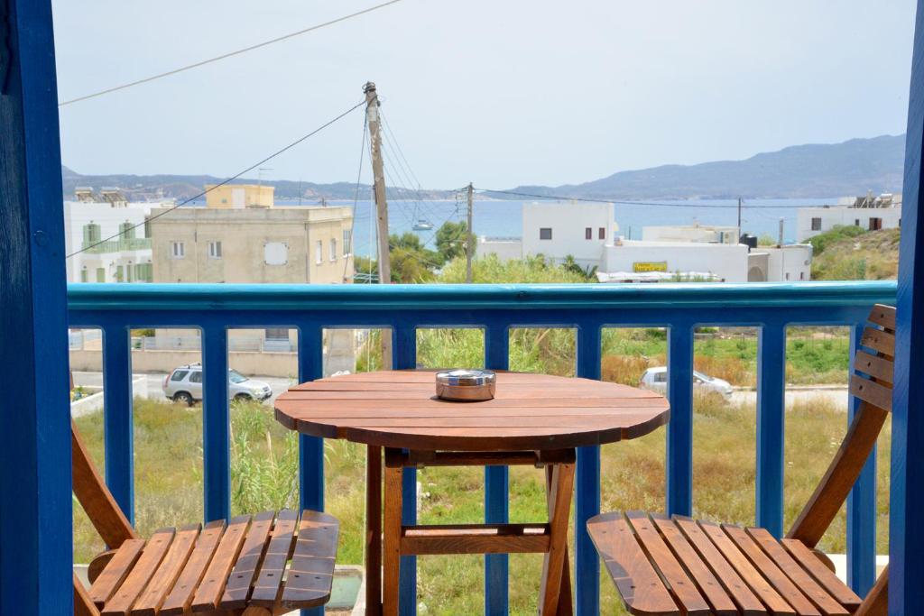 un tavolo in legno e 2 sedie sul balcone di Finikas Studios ad Adámas