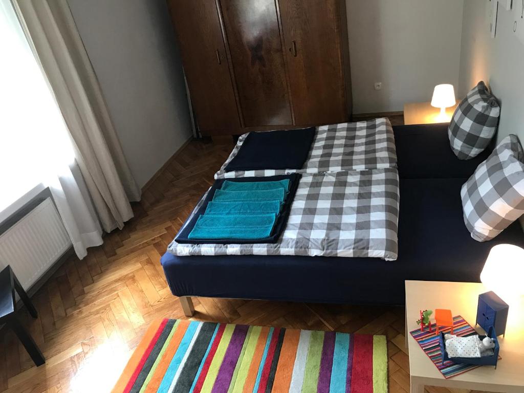 a living room with a bed and a rug at Apartment In Center-Near Everywhere in Toruń