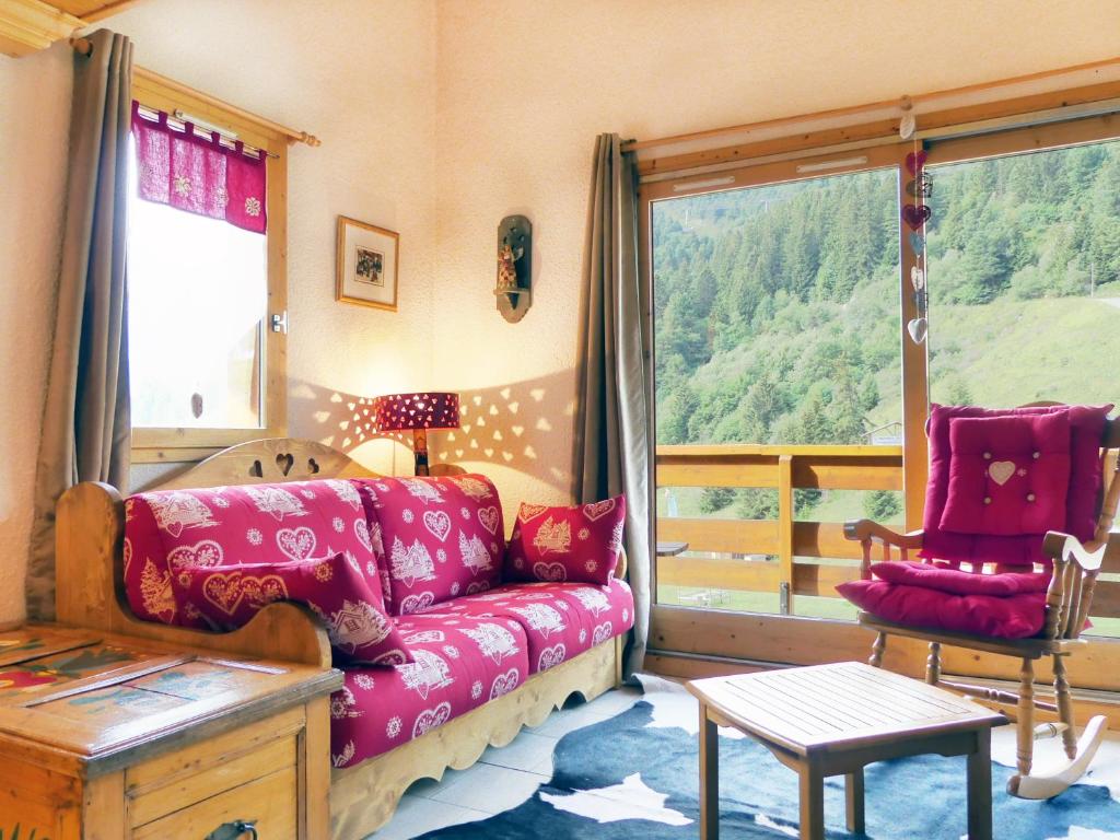 un salon avec un canapé et une grande fenêtre dans l'établissement Residence Olympie I, à Méribel