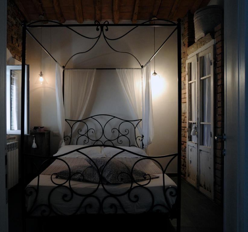 a bedroom with a black canopy bed with white sheets at Casa Del Principe in Gambassi Terme