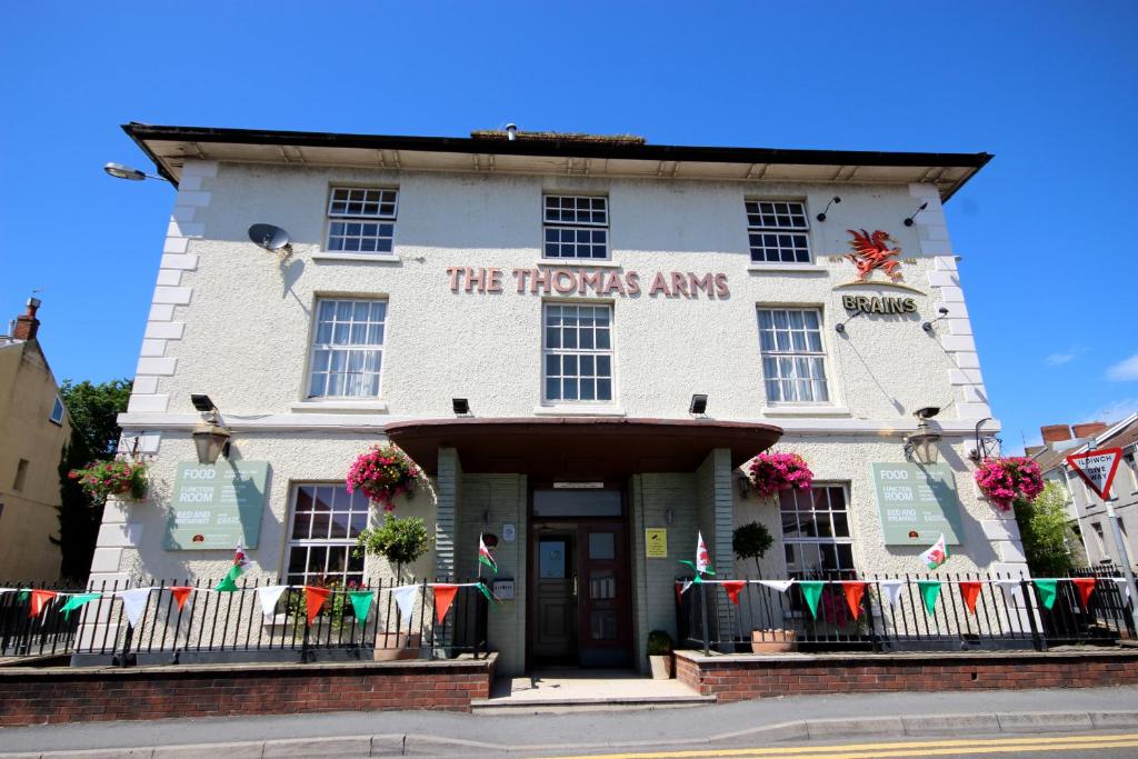 a white building with a sign on the front of it at Thomas Arms Hotel in Llanelli