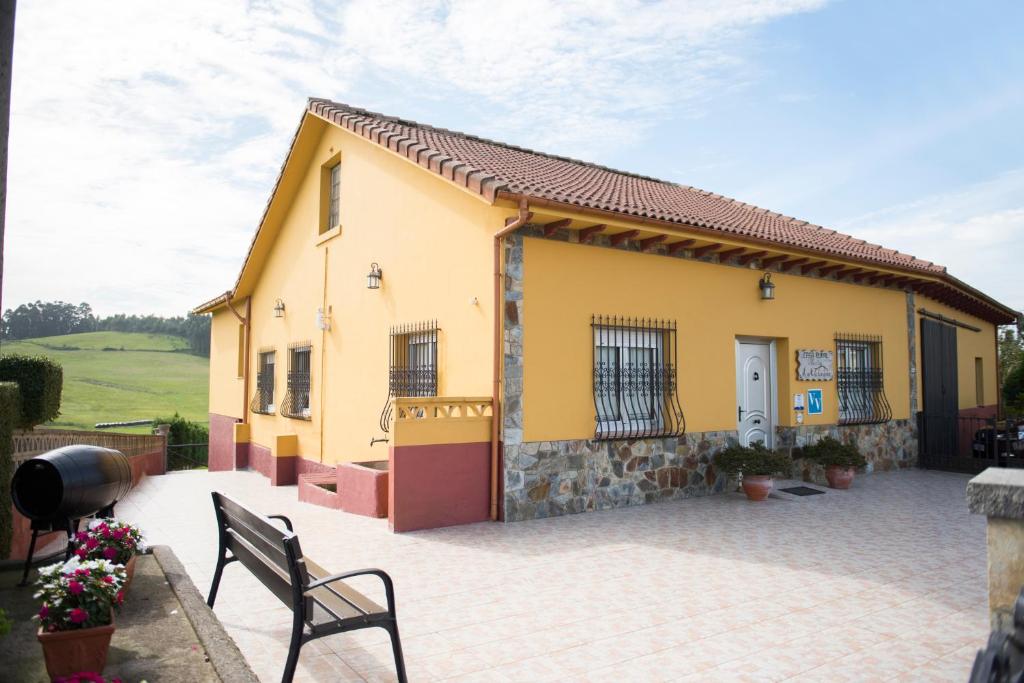 a small yellow house with a patio in front of it at Maria la Carbayeda in Luanco