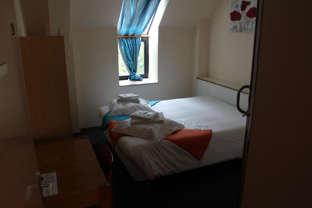 Habitación pequeña con cama y ventana en Abbaye de Belval en Troisvaux