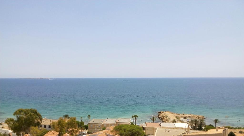 Blick auf das Meer mit Gebäuden und Bäumen in der Unterkunft Relax and sun in Santa Pola