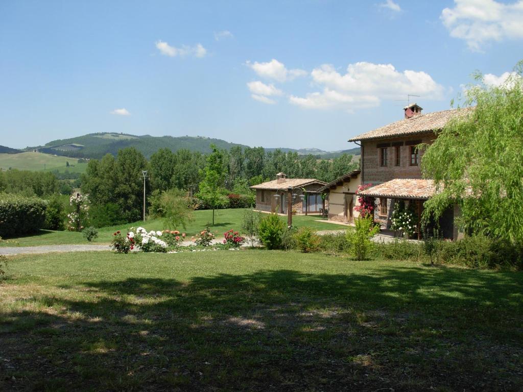a house in a field with a yard at Agriturismo Santa Veronica in Acquapendente