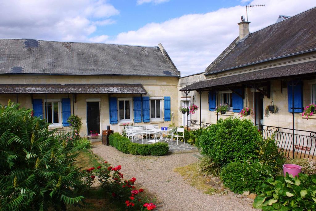 zwei alte Häuser mit blauen Rollläden und einem Garten in der Unterkunft La Bretonnière, Longère Picarde in Passel