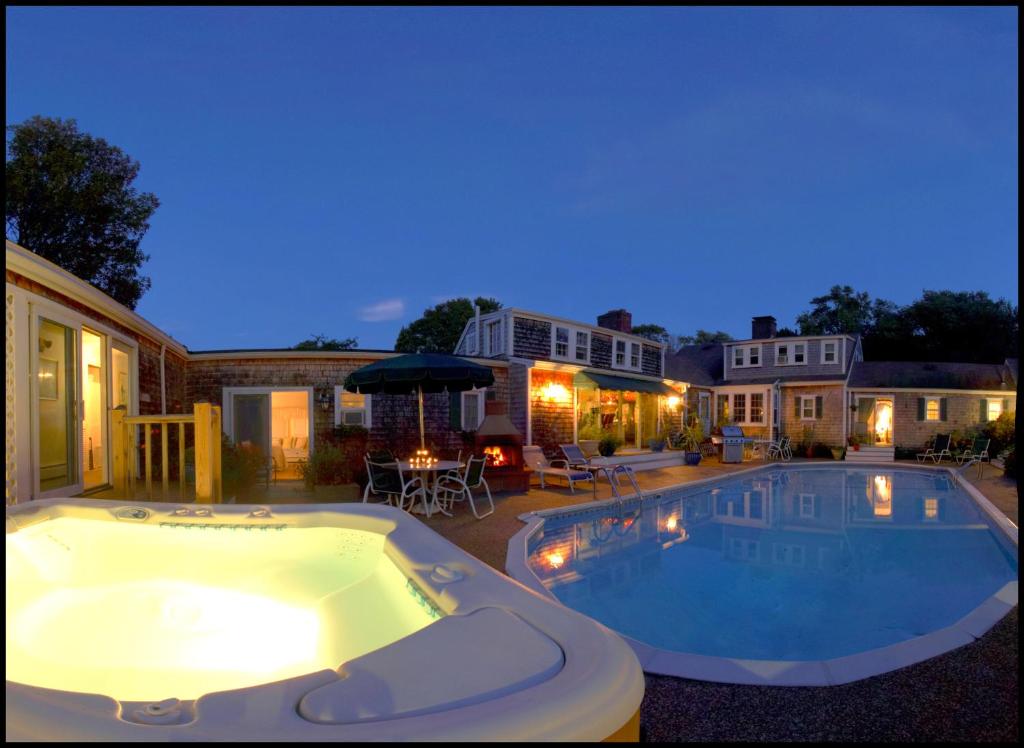 a large swimming pool in a backyard at night at Lamb and Lion Inn in Barnstable