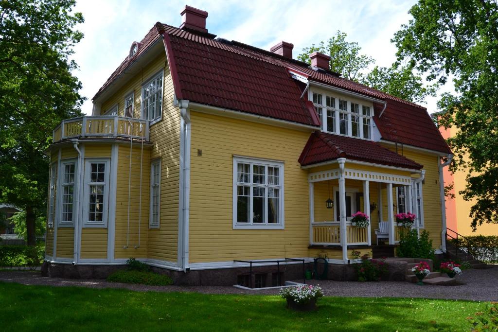 uma casa amarela com um telhado vermelho em Villa Baumgartner em Lovisa