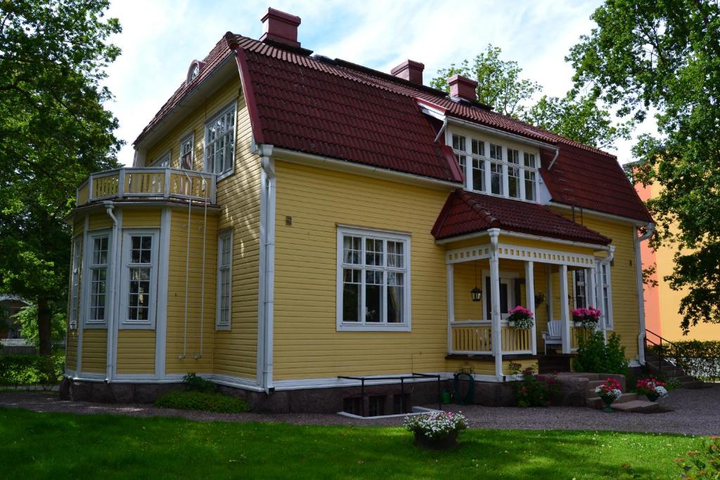 una casa amarilla con techo rojo en Villa Baumgartner, en Lovisa