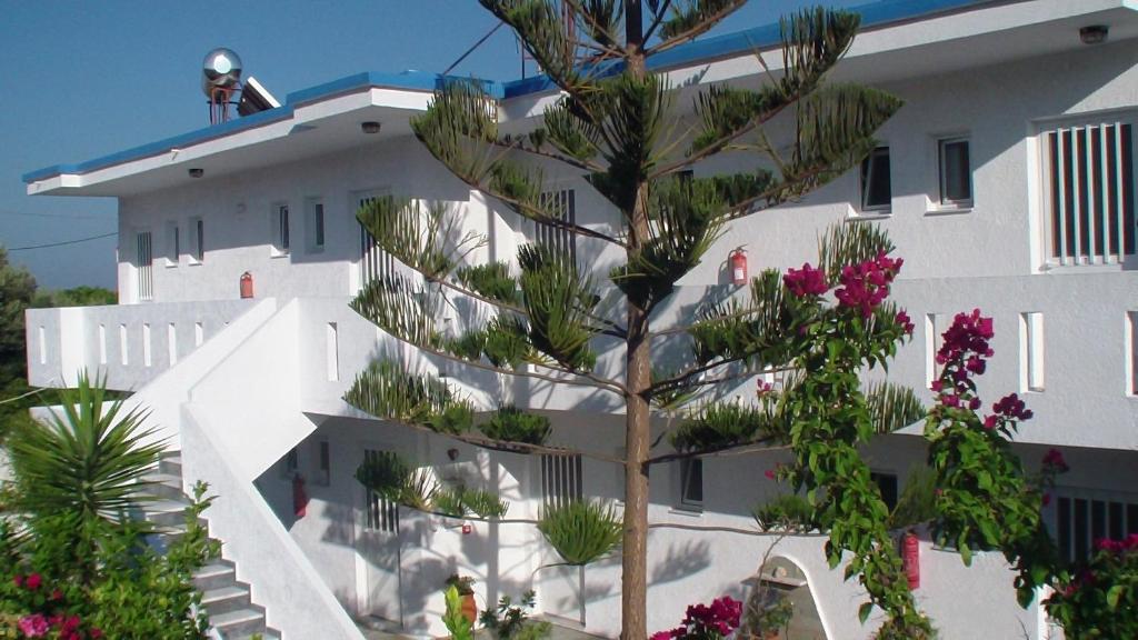 a white building with a tree in front of it at Creta Vassakis Studios in Kefalos