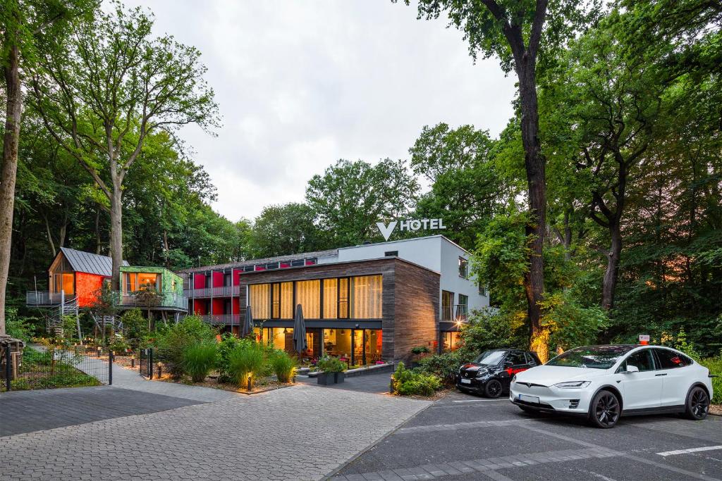 een witte auto geparkeerd voor een gebouw bij V-Hotel in Bonn