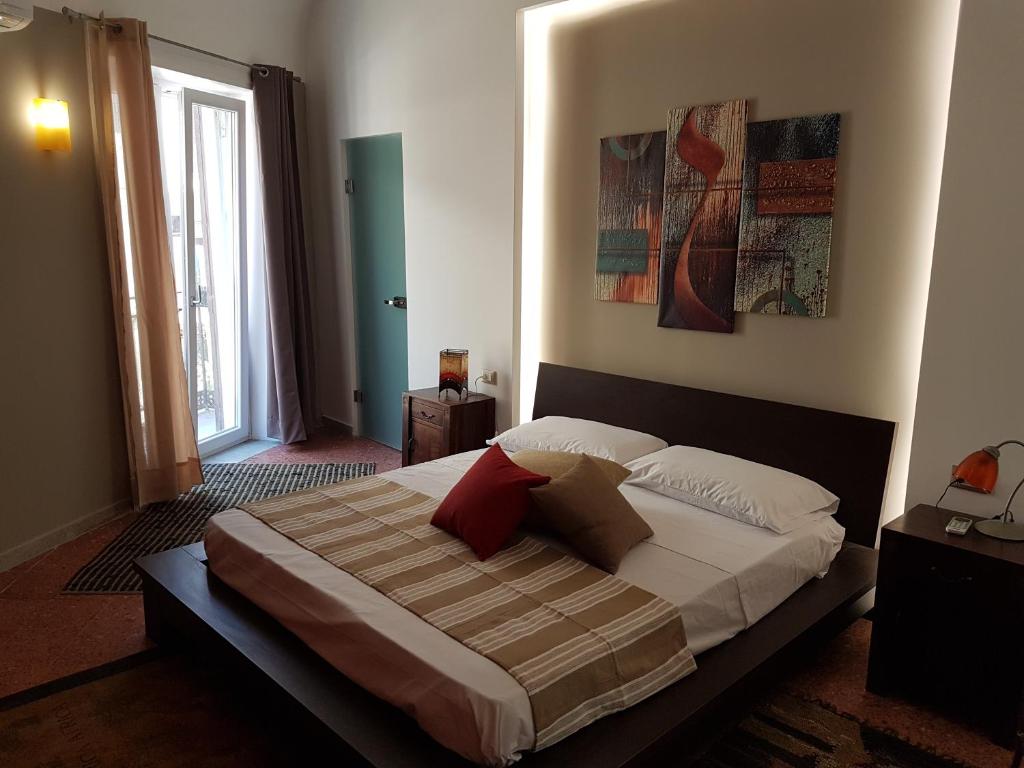 1 dormitorio con 1 cama grande y 2 almohadas en Vittorio Emanuele Appartamenti, en Palermo