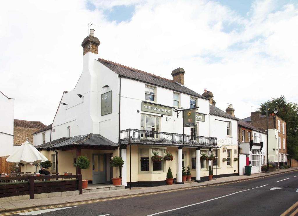 un edificio blanco al lado de una calle en Flower Pot Hotel, en Sunbury