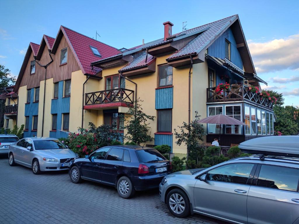 a group of cars parked in front of a building at Inkliuzas in Nida