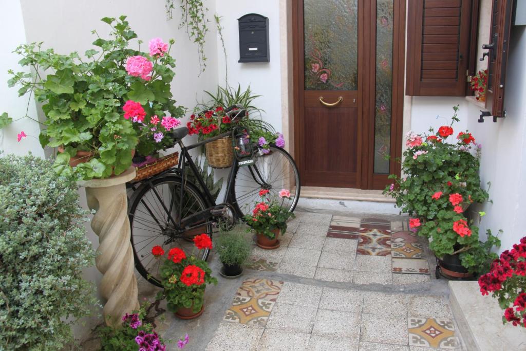 ein Fahrrad, das vor einer Tür mit Blumen parkt in der Unterkunft Abitazione in Galatone