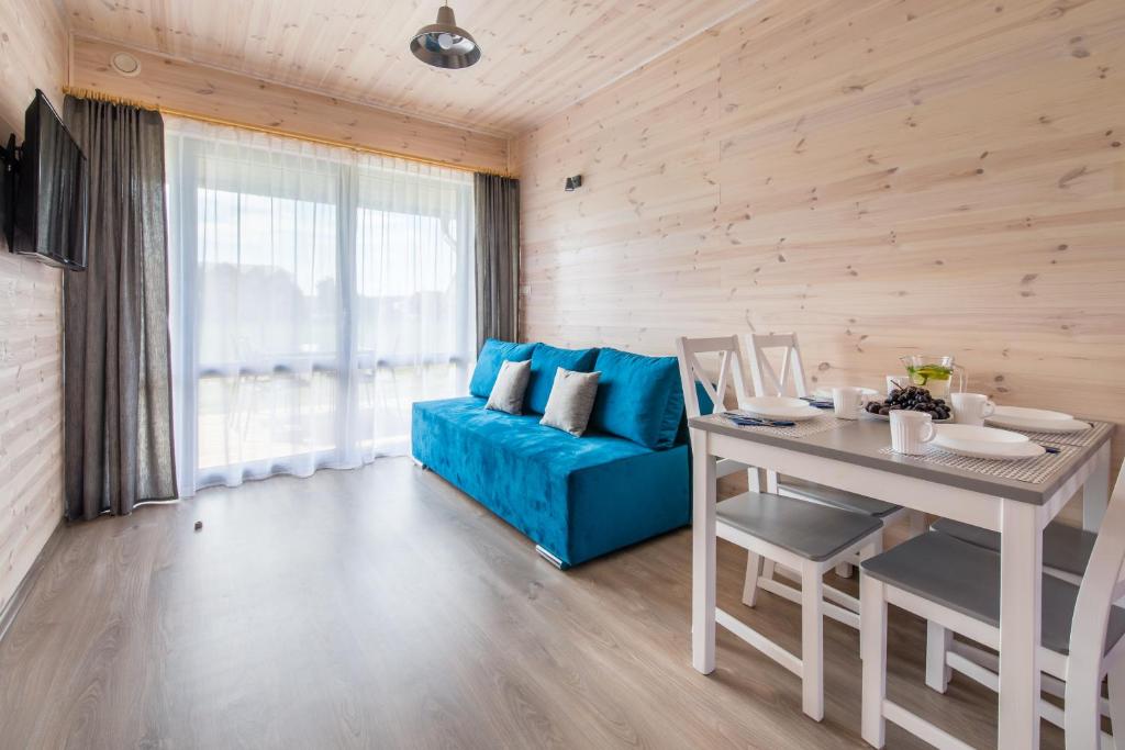 a living room with a blue couch and a table at Amelia in Krynica Morska