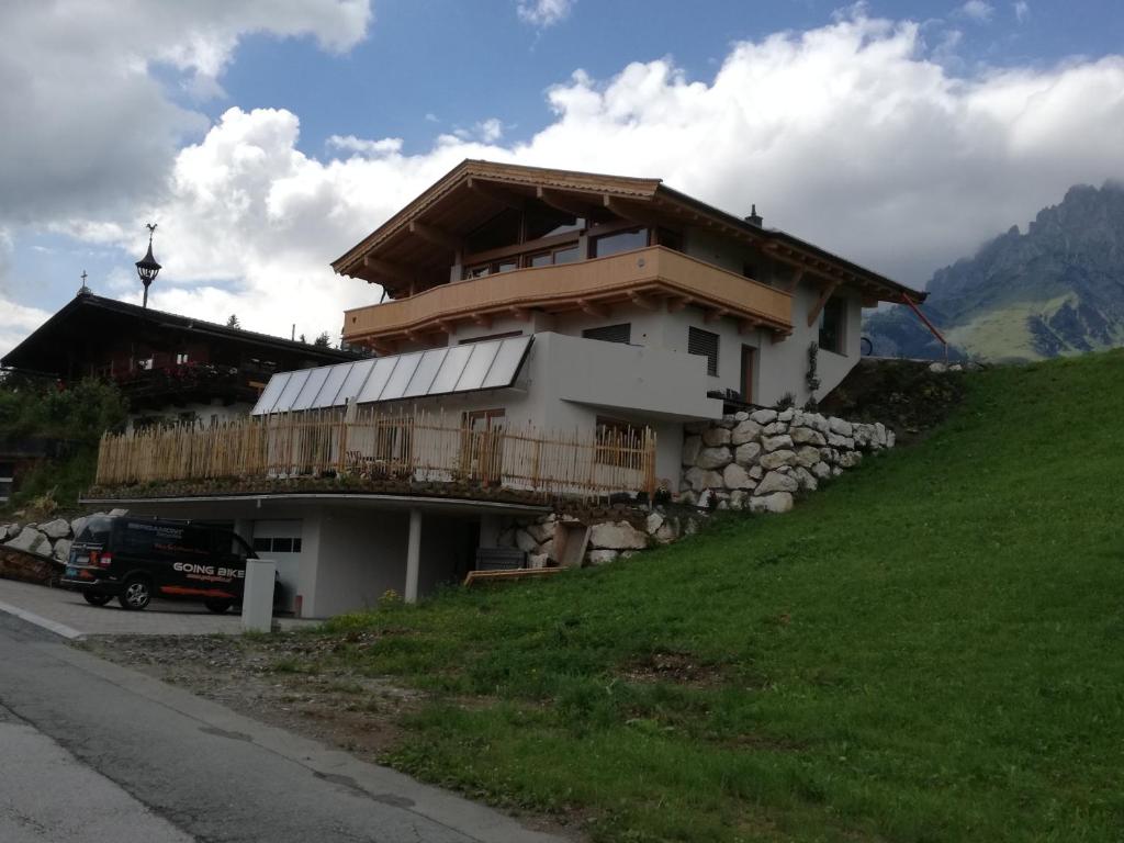 un bâtiment sur le côté d'une colline dans l'établissement Appartement Viktoria, à Going am Wilden Kaiser