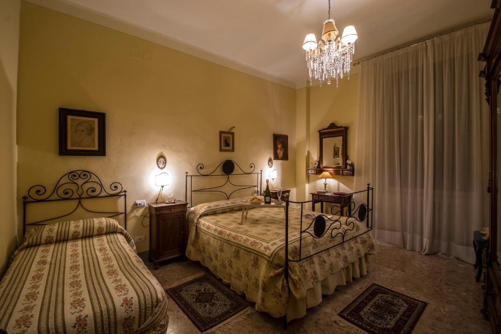 una camera con due letti e un lampadario a braccio di Relais Buonfanti a Pistoia