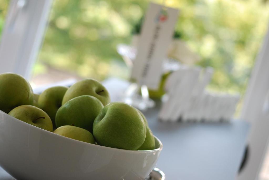 a bowl of green fruit sitting on a table at Hotel Aurora Duino in Duino