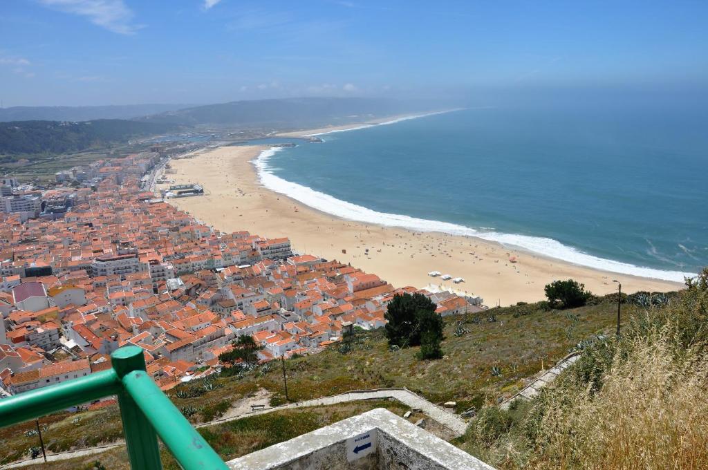 vista su una spiaggia con città e oceano di Casa de Zira a Nazaré