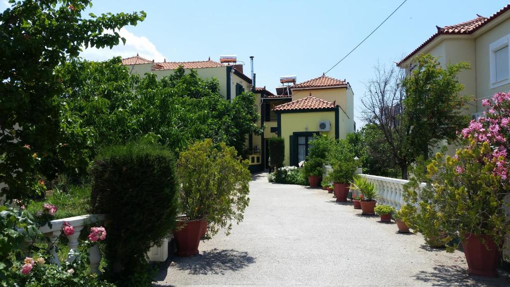 a walkway through a garden with flowers and plants at Elektra Apartments & Studios in Petra