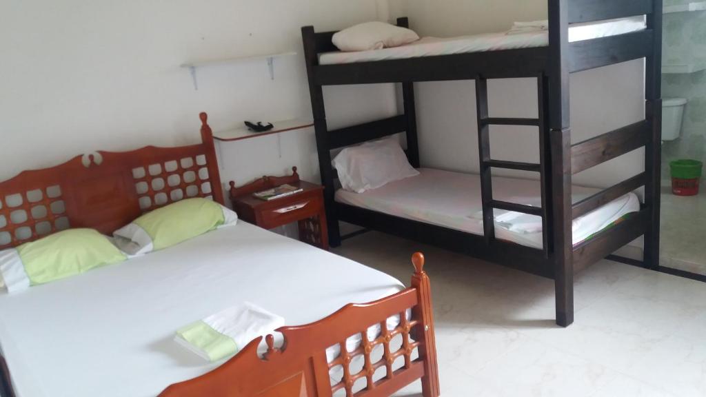 a room with two bunk beds and a bed and a chair at Casa Campestre La Heredera in Villavicencio