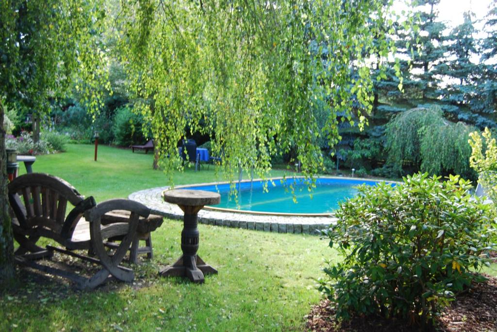 un banco y una mesa en un patio con piscina en Ferienwohnung Aronia, en Ludwigslust