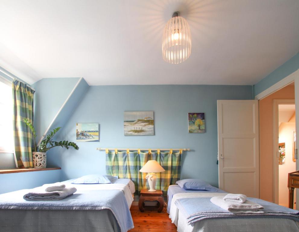 two beds in a room with blue walls at Manoir des Turets in Yvré-lʼÉvêque