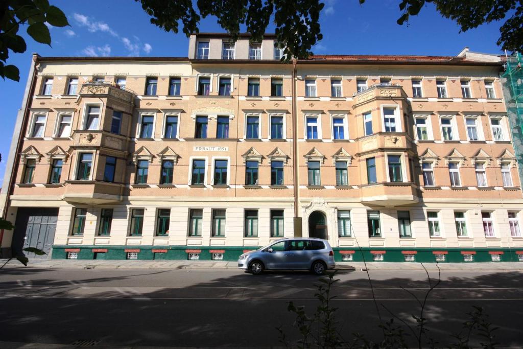 a car parked in front of a large building at VacApps Apartments in Leipzig