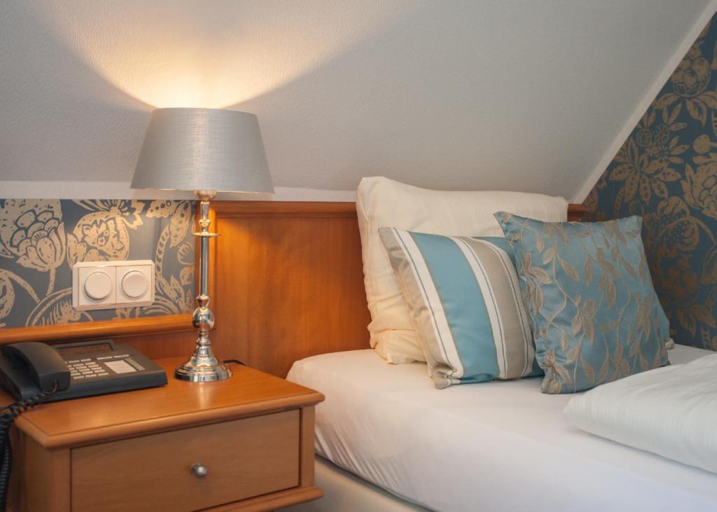 - une chambre avec un lit doté d'une lampe et d'un téléphone dans l'établissement Hotel Rech, à Brilon