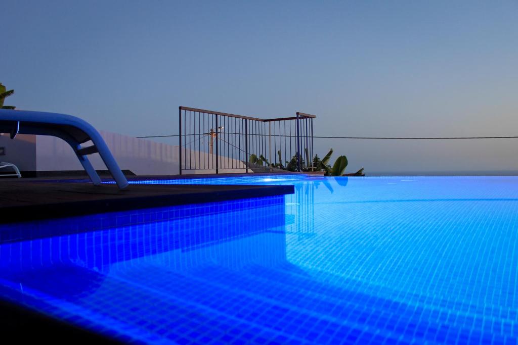 uma piscina com luzes azuis em cima em Casa das Andorinhas em Estreito da Calheta