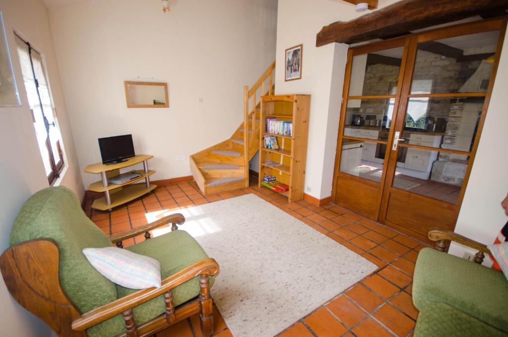 un salon avec deux chaises et un escalier dans l'établissement Joyeux, à Saint-Laurent-de-Céris